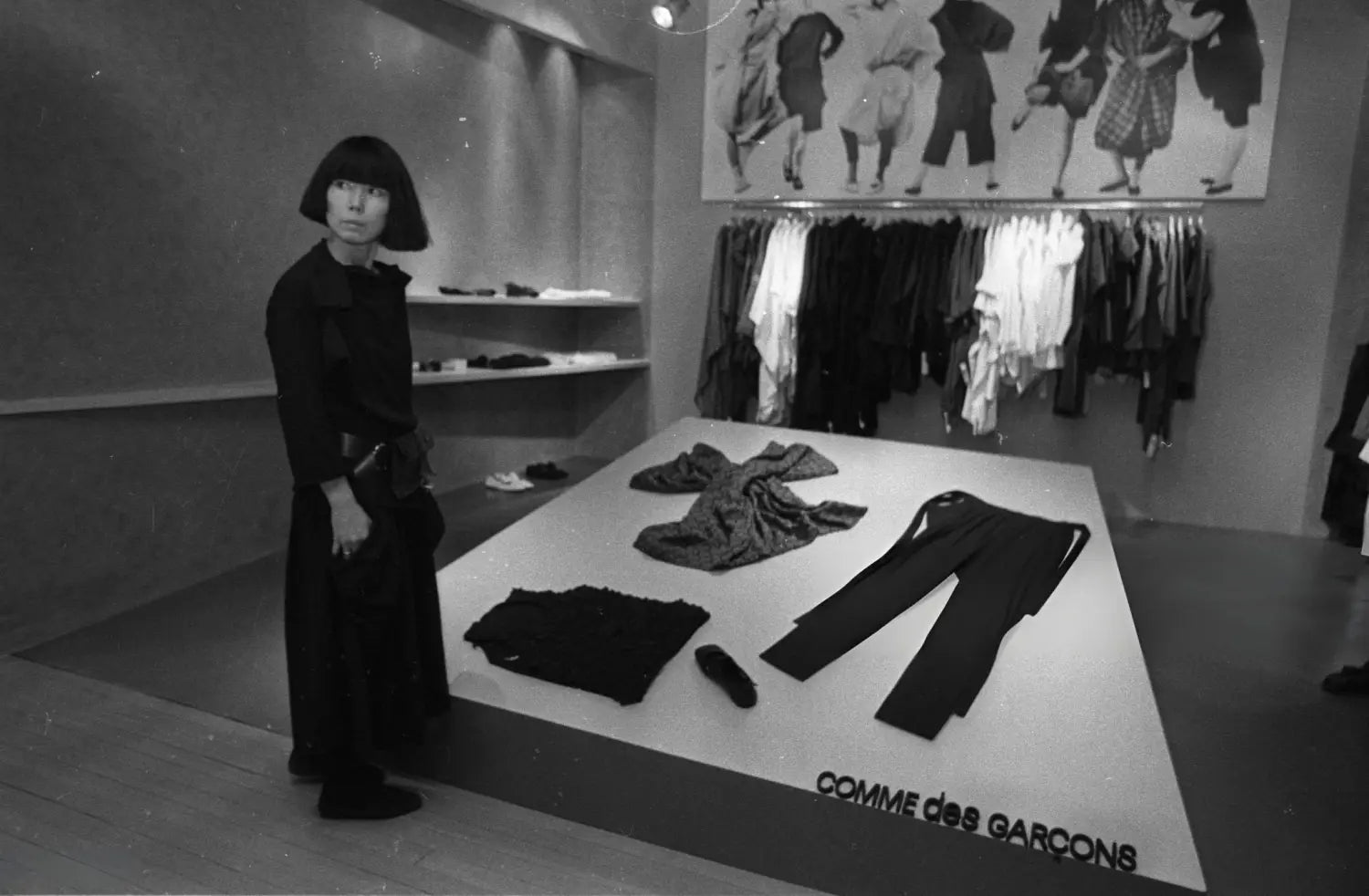 Black minimalist Comme des Garcons clothing on white platform