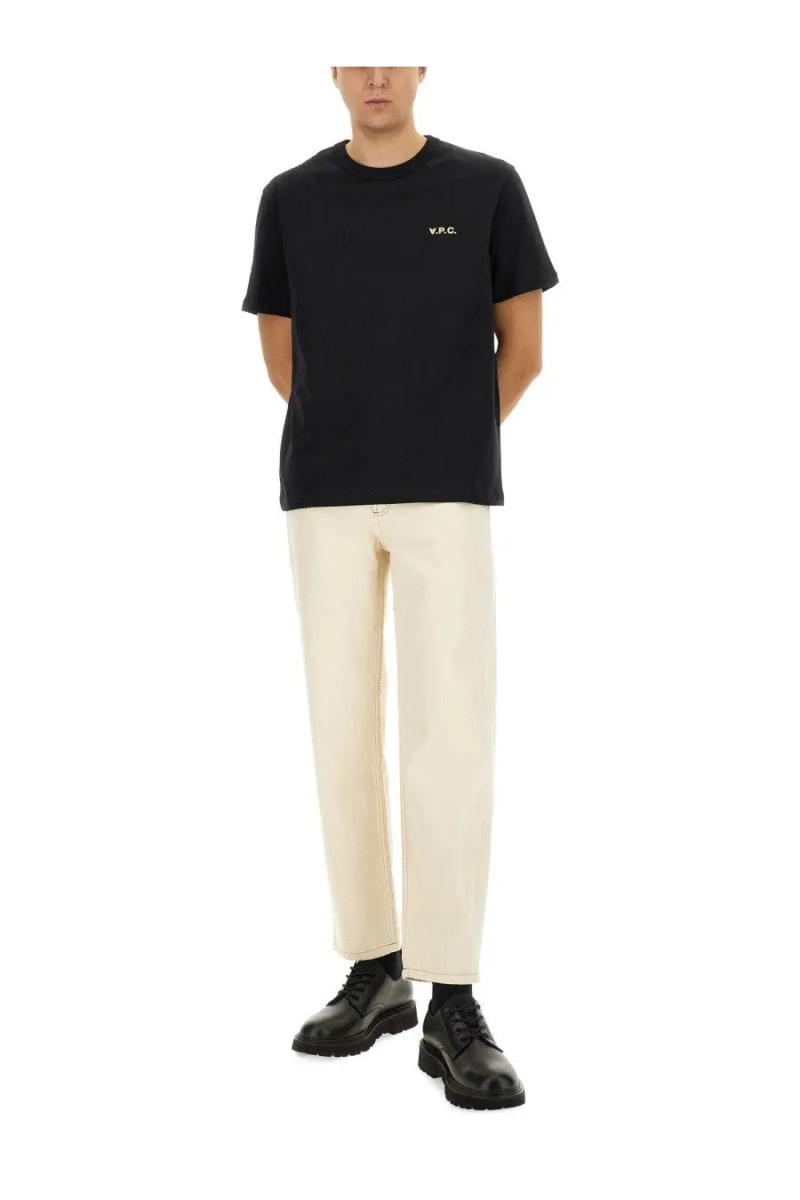 Black short-sleeved cotton t-shirt with white embroidered logo paired with APC men’s beige martin jeans