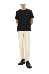 Black short-sleeved cotton t-shirt with white embroidered logo paired with APC men’s beige martin jeans