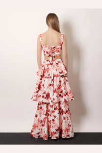 A woman wears an actualee women’s flounced long skirt pink with tiered ruffles and pink red rose floral pattern