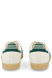 Cream-colored adidas men’s sneaker samba with green knit heel tabs and three white stripes