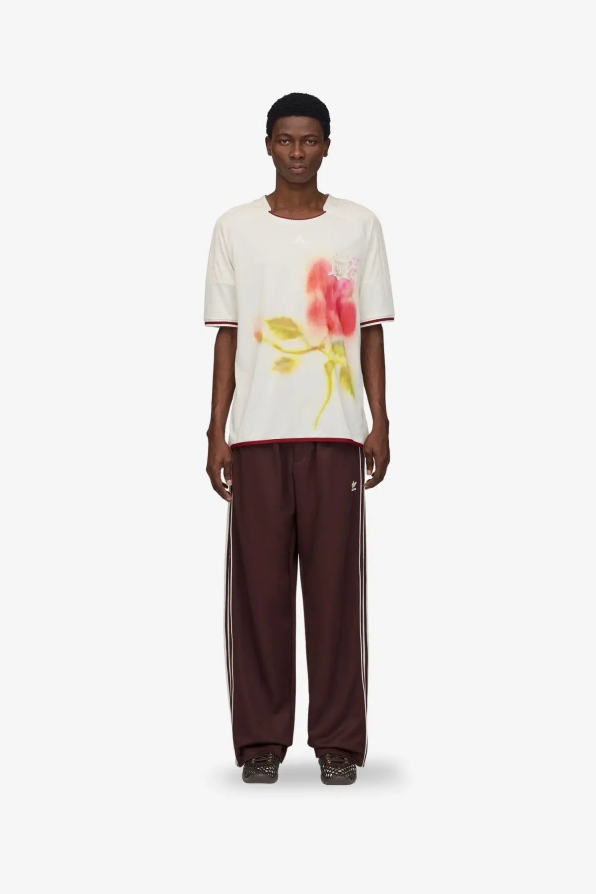 White short-sleeved t-shirt with pink rose graphic and red trim paired with adidas originals by wales bonner brown recycled track trousers