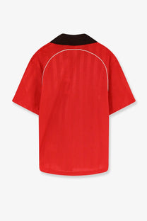 Red short-sleeved nylon shirt with black collar and white shoulder piping from adidas originals by wales bonner