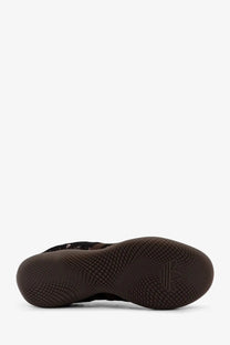 Black adidas basketball shoe with textured rubber sole and subtle branding on the heel viewed from the back