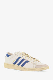 Cream-colored leather adidas Originals x Willy Chavarria men’s Chavarria Jabbar dress sneaker with bold blue stripes and laces