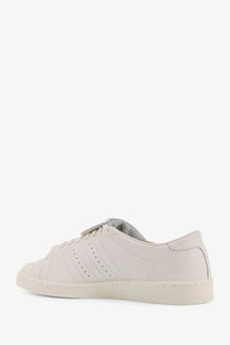 Cream-colored leather adidas Originals x Willy Chavarria men’s low top sneakers with three-stripe design and rubber toe cap