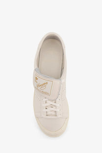 Cream-colored leather adidas stan smith sneaker with gold branding and classic lace-up design for men