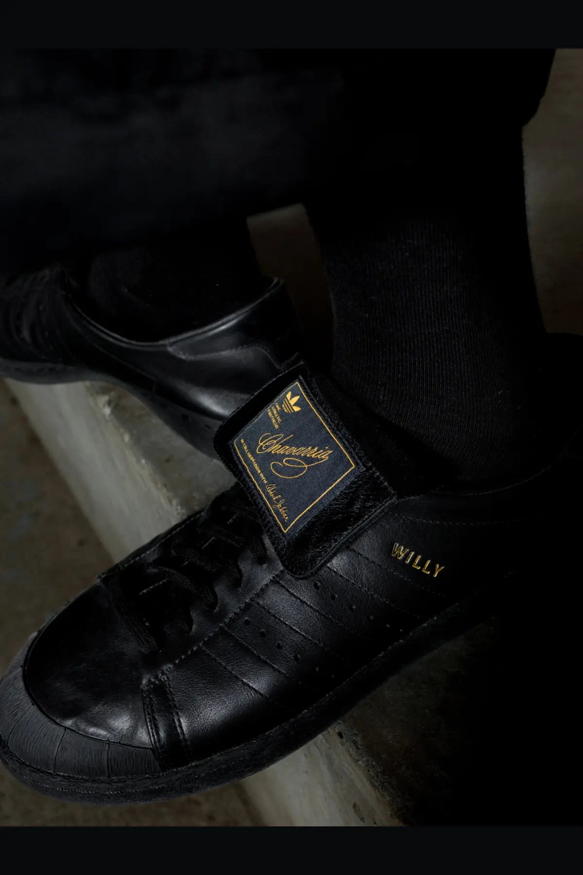 Adidas Originals x Willy Chavarria men’s black leather sneakers with gold branding and willy text on the side