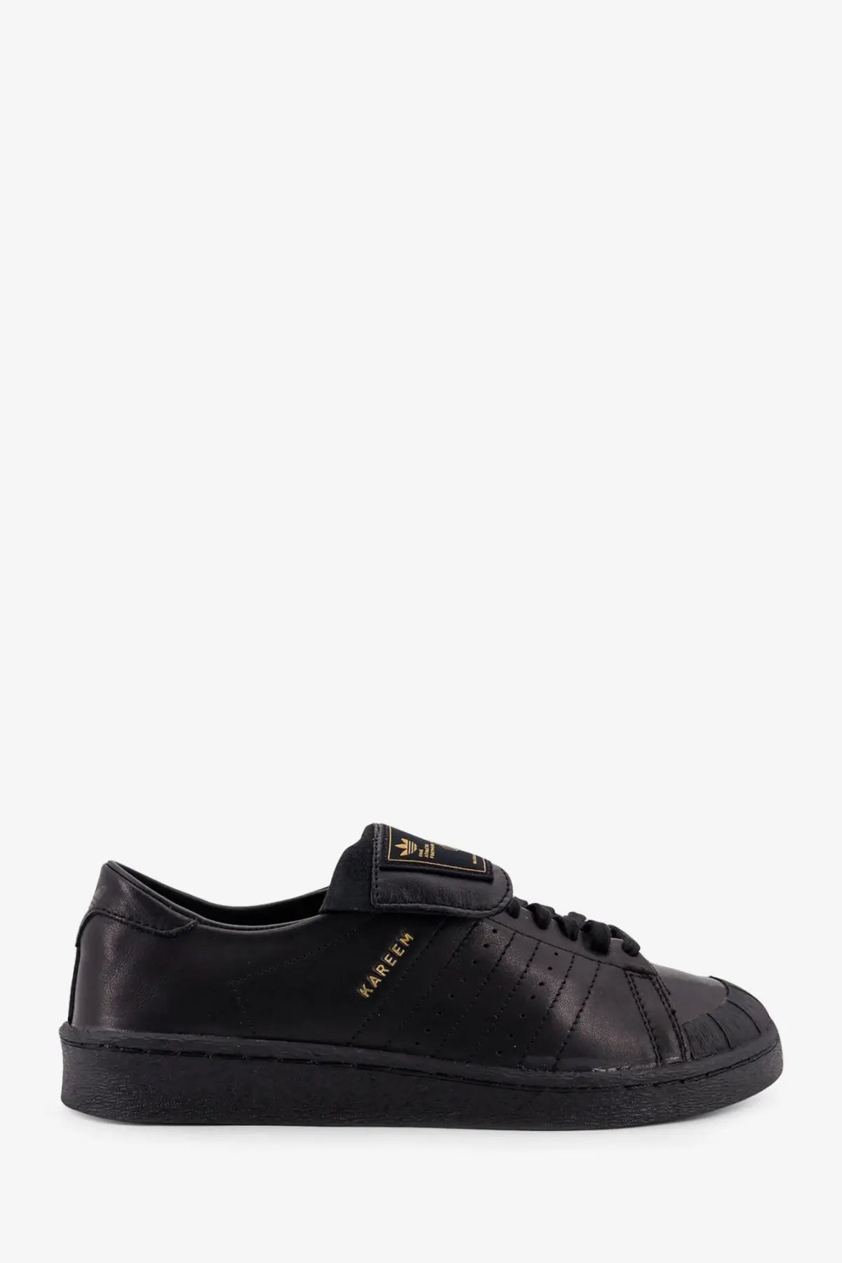Adidas Originals x Willy Chavarria black leather sneaker with gold branding and classic shell-toe design