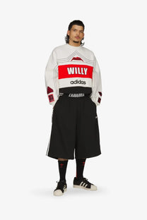 White long-sleeved sweatshirt with bold red and black graphic panels and willy logo above adidas on recycled nylon shorts