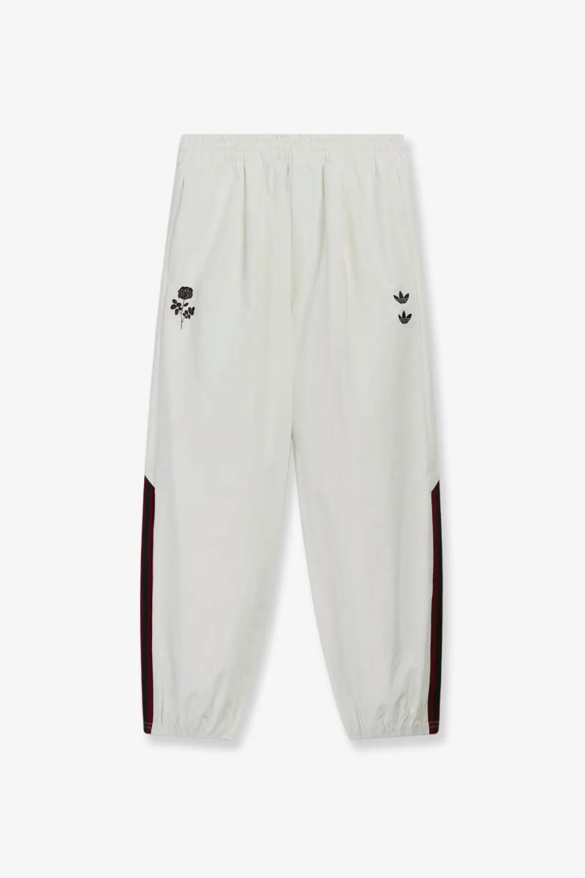 Cream-colored adidas Originals x Willy Chavarria men’s recycled nylon trousers with black embroidered rose and burgundy stripes