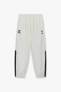 Cream-colored adidas Originals x Willy Chavarria men’s recycled nylon trousers with black embroidered rose and burgundy stripes