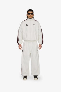 White adidas Originals x Willy Chavarria men’s recycled nylon trousers with maroon side stripes and black floral embroidery