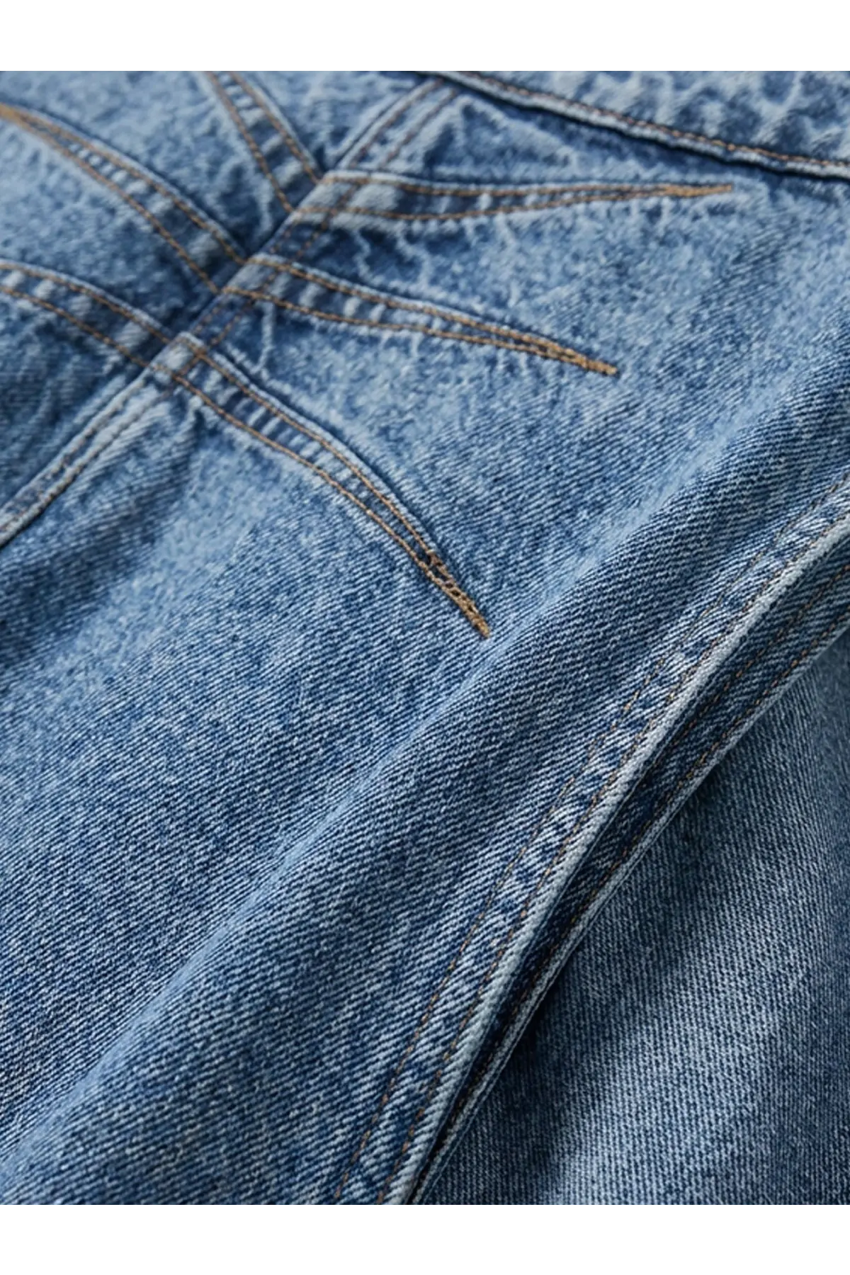 Alaïa women’s blue denim jeans in medium wash with visible stitching and slightly worn texture on front side