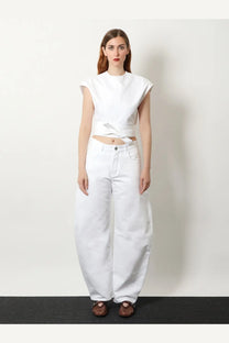 Alaïa women’s white cotton sleeveless cropped top with front tie detail paired with high-waisted white denim pants