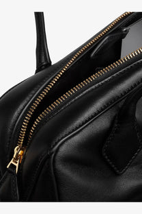 Alaïa women’s le teckel black leather shoulder bag with gold tone zipper and hardware shown from the back side