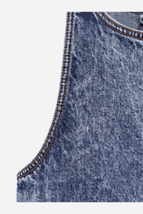 Alaïa women’s blue faded denim sleeveless peplum top with visible stitching along the shoulder seam