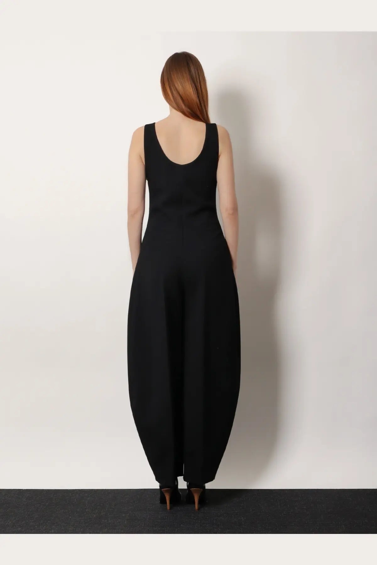 Alaïa women’s black round virgin wool sleeveless jumpsuit with wide flared legs shown from the back side