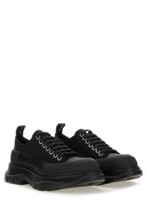 Alexander McQueen women’s tread slick sneaker black with chunky soles and silver eyelets in leather material