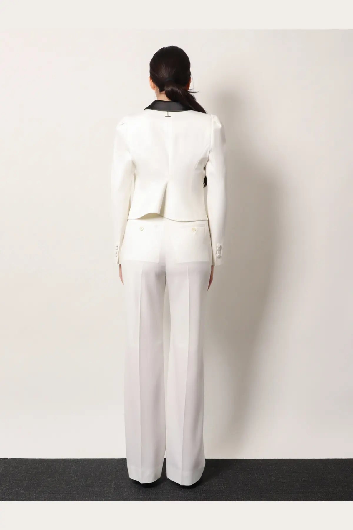 Alexander McQueen women’s white wool blazer with black collar and subtle pleating at the back shown from the back side