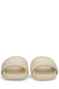 Beige alexander mcqueen slide sandals with textured fabric upper and embossed branding for stylish slip on wear