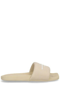 Beige canvas slide sandal with minimalist design and subtle brand logo on strap for women by Alexander Wang