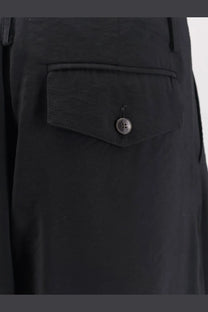 Alysi women’s black modal trousers with a single buttoned flap pocket featuring contrasting stitching on the back side