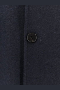Detail of a dark navy four-hole button with subtle sheen on amaranto men’s outdoor wool coat blue