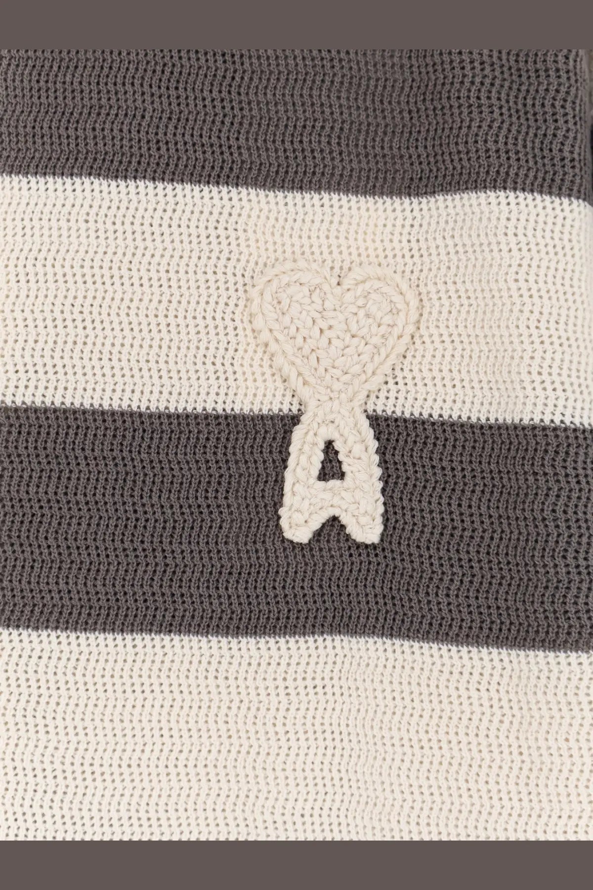 A cream-colored crocheted heart emblem with a cutout on a ami paris men’s ami de coeur striped cotton cardigan white