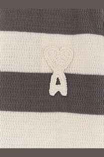 A cream-colored crocheted heart emblem with a cutout on a ami paris men’s ami de coeur striped cotton cardigan white