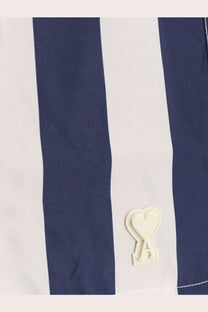Ami Paris men’s nylon swim shorts in white with navy blue stripes and a cream heart-shaped logo patch on the side