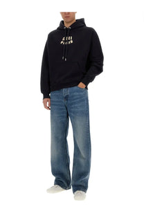 Black ami paris unisex hoodie with cream colored logo lettering across the chest in a soft cotton blend