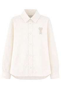 Cream-colored ami paris unisex overshirt with long sleeves and subtle embroidered bear motif on left chest