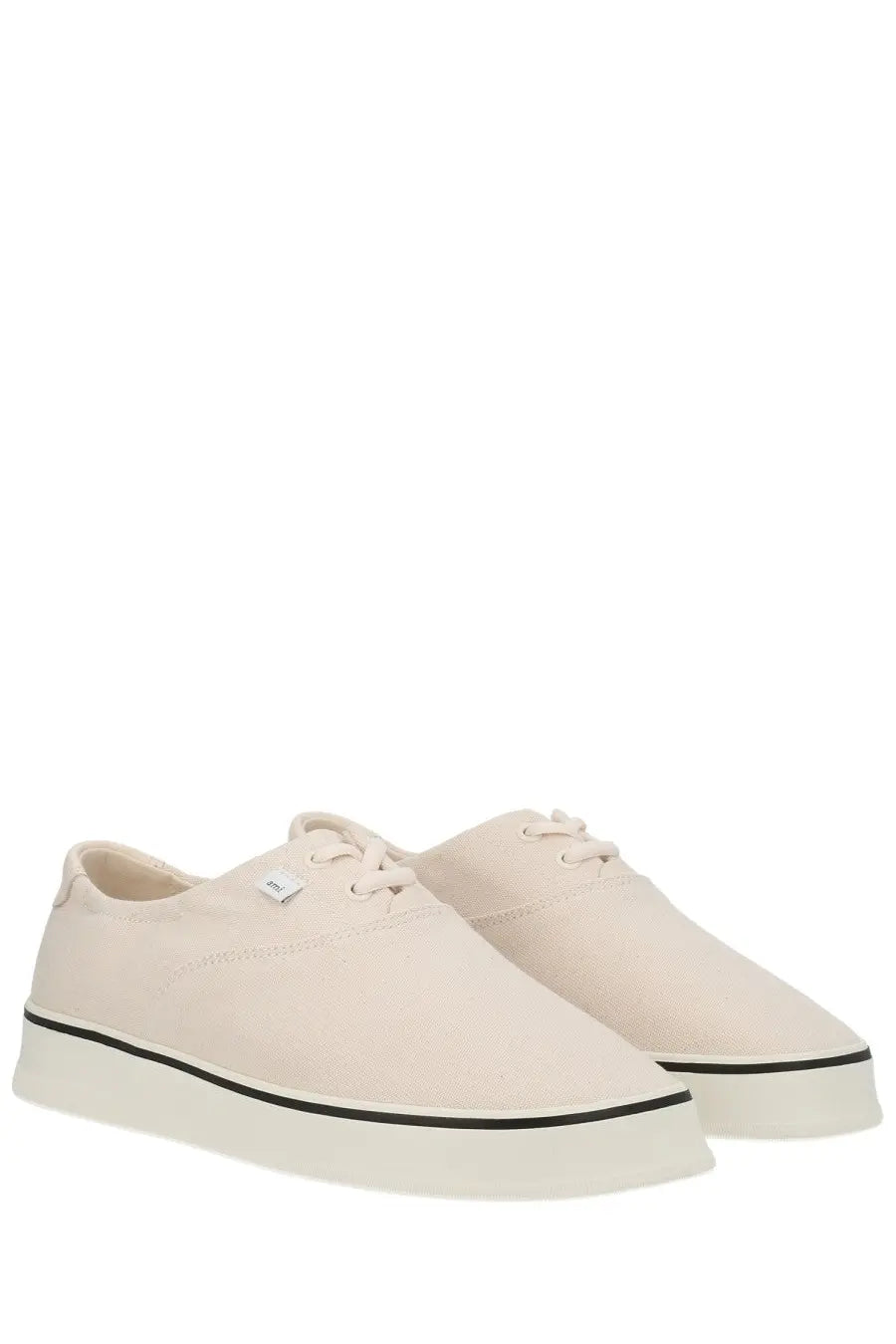 Cream-colored ami paris unisex tennis sneaker in canvas with black rubber sole stripe and white laces