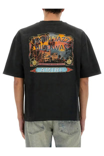 Amiri men’s black jazz hideaway t-shirt with vibrant vintage tropical hideaway graphic print and palm trees