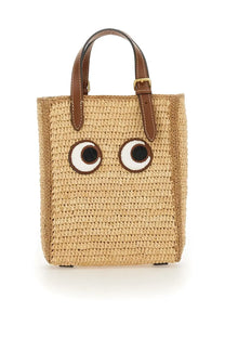 Anya Hindmarch women’s beige woven straw tote bag with embroidered eyes and brown leather handles