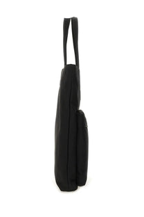 Anya Hindmarch women’s black canvas tote bag with two slender handles and a side pocket for easy access