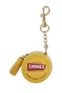 Anya hindmarch women’s yellow leather keychain shaped like a carmex lip balm tube with brand logo and text