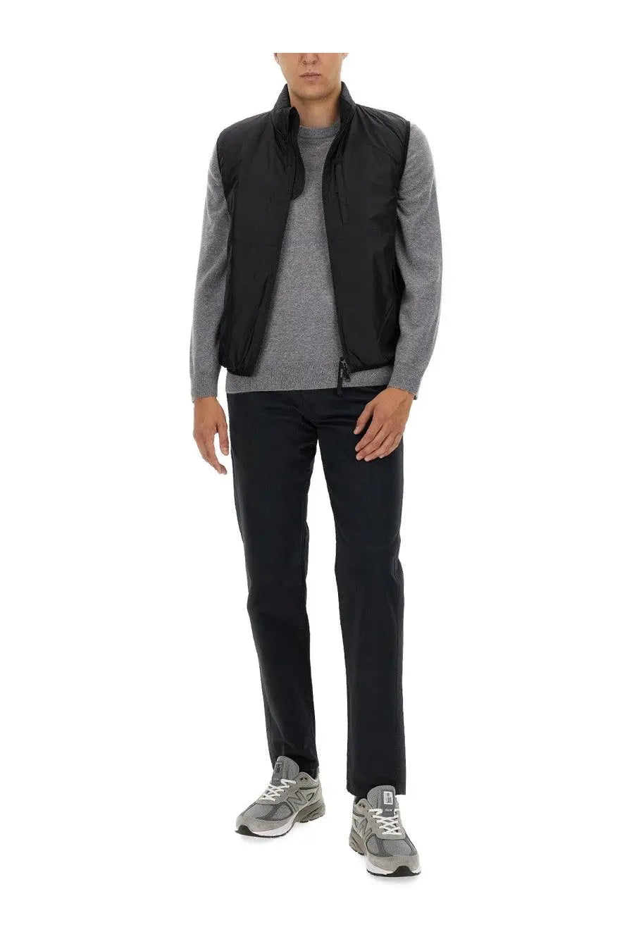 Black nylon vest with stand-up collar and front zipper worn over gray patterned shirt in aspesi men’s chino pants blue