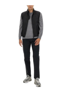 Black nylon vest with stand-up collar and front zipper worn over gray patterned shirt in aspesi men’s chino pants blue