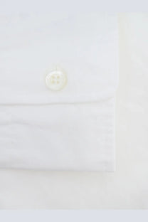 A crisp white cotton button-down shirt cuff with an off-white four-hole button from aspesi men’s fred collection