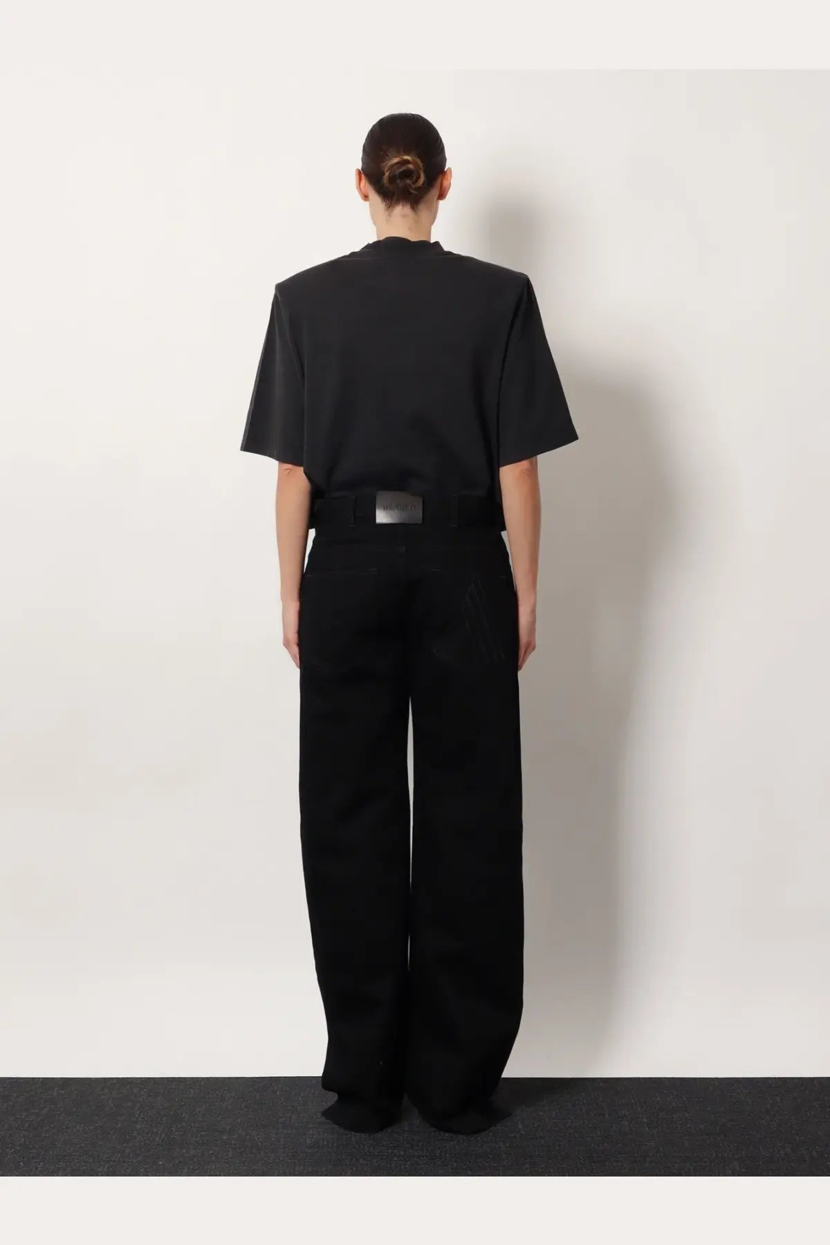 Black oversized short-sleeved top with structured shoulders paired with the attico women’s black denim trousers black