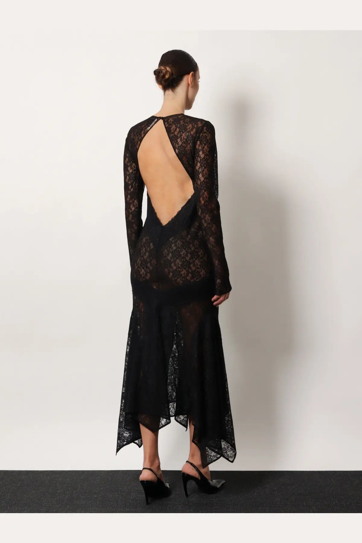 The attico women’s black lace dress with a backless design and long sleeves shown from the back side