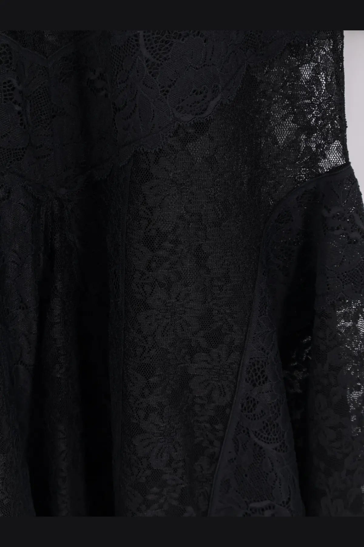 The attico women’s lace dress black featuring intricate floral patterns and flowing sheer fabric in black