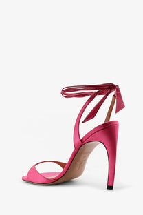 The Attico women’s Ora satin sandals pink feature a vibrant fuchsia high heel with a slender heel and ankle strap bow
