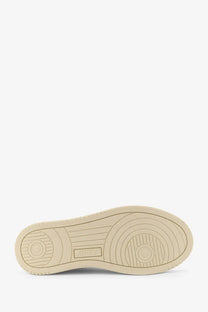 Beige rubber sole with concentric circular tread patterns and rectangular brand logo on autry women’s white leather sneakers