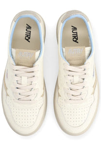 Cream-colored leather autry women’s medalist low sneaker with perforated detailing and light blue lining