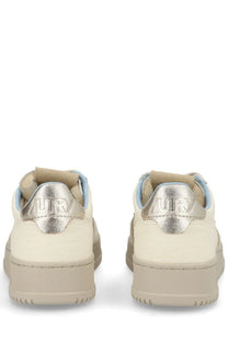 Cream-colored Autry women’s Medalist low sneakers with metallic silver heel tabs embossed with urb branding visible from back