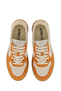 Autry women’s medalist low sneaker in orange and white suede and leather with a gum rubber sole