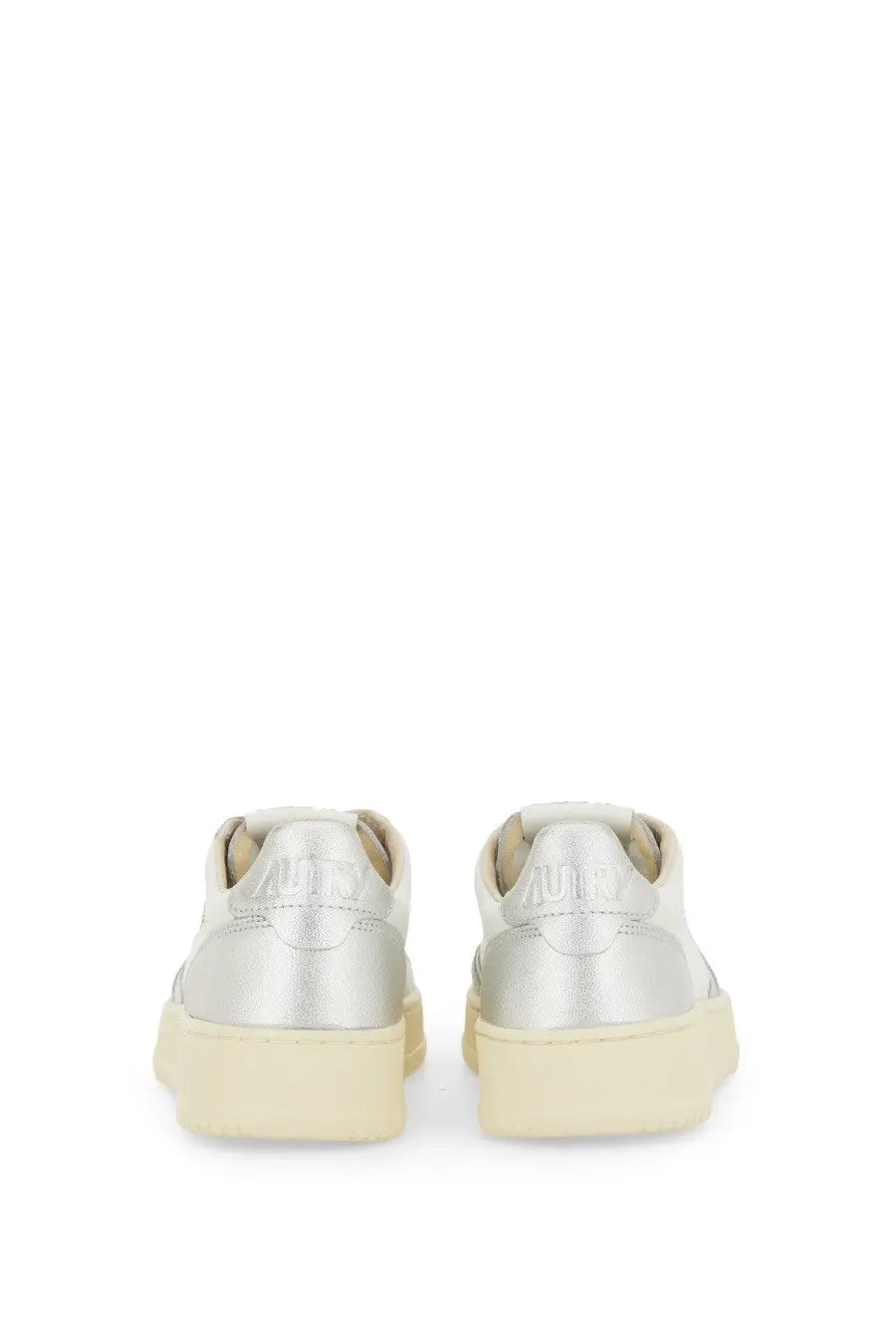 Back view of autry women’s medalist low silver metallic sneakers with cream rubber sole and embossed brand heel